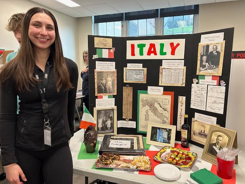 An L-P student next to her family heritage project.