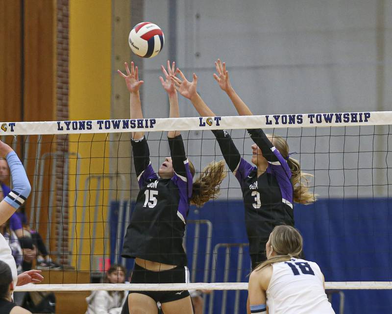 Downers Grove North's Sam Hancock (15) and Sienna Shelton (3) attempt a block during Class 4A Lyons Sectional Semifinal volleyball match between Downers Grove South at Downers Grove North. Nov 4, 2025 in La Grange.