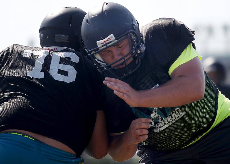 Jacob Varys slams into a teammate while running drills during football practice Aug. 12 at Woodstock North High School in Woodstock.