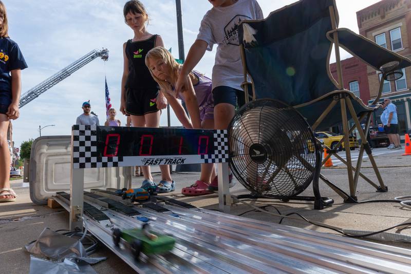 Children watch toy cars race down ramp at the 20th annual Cruise Night on Friday, August 8, 2025 on Main Street in Marseilles.