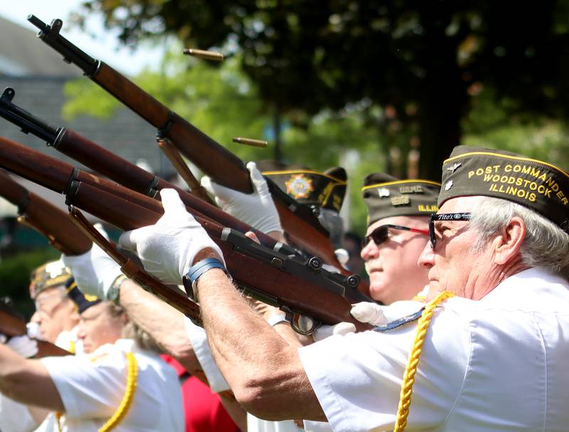 Service members perform a rifle salute during a Memorial Day service and parade in downtown Woodstock on Monday, May 26, 2025.