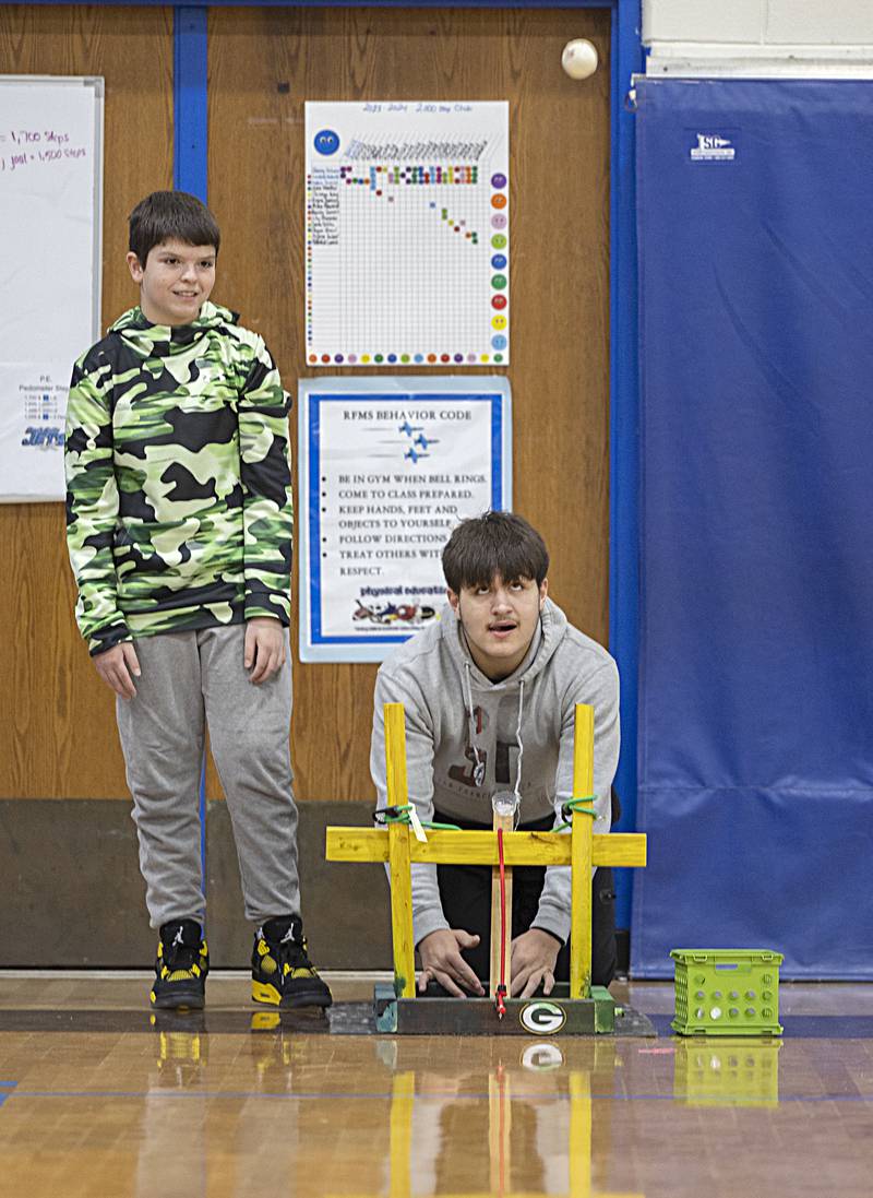 Eighth graders Zein Tefiku (left) and Zach Walker watch their catapult go to work Friday, Dec. 15, 2023 at Rock Falls Middle School.