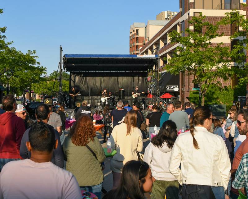 Community members enjoy the weather and a performance by the band Reception on Saturday May 31, 2025, during the Elmhurst Summer Kick Off Party held at City Centre Fountain Plaza in Elmhurst.