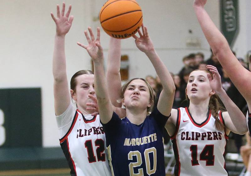 Marquette's Kaitlyn Davis lets go of a shot over Amboy/Ohio's Addison Pertell and Jillian Anderson during the Class 1A Regional championship on Thursday, Feb. 20, 2025 at St. Bede Academy.