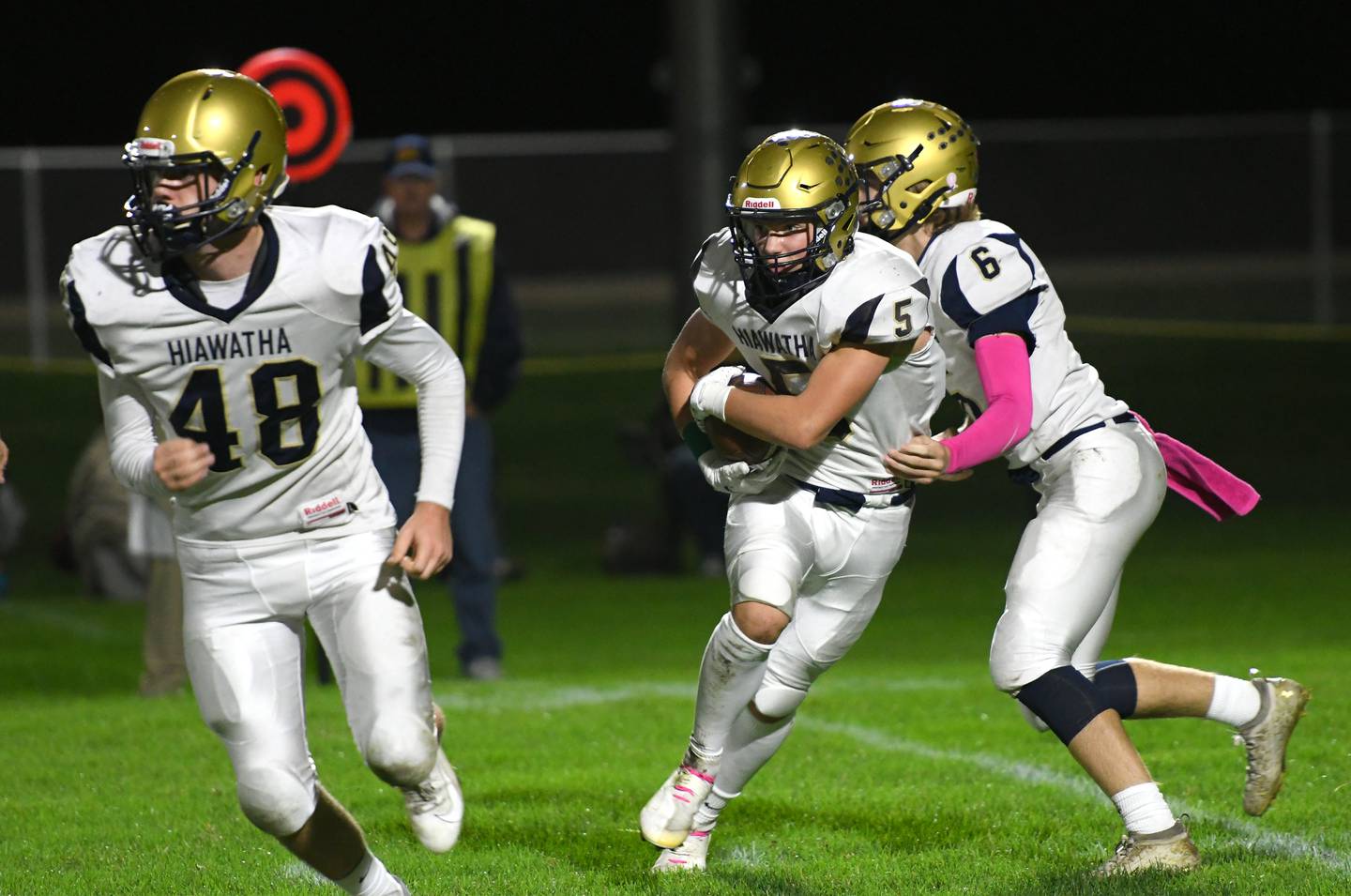 Kirkland-Hiawatha's Cole Brantley looks for a gap in the line as he gets the ball from quarterback Chris Korb as lineman Zach Edwards blocks during Friday night 8-man football action in Polo.