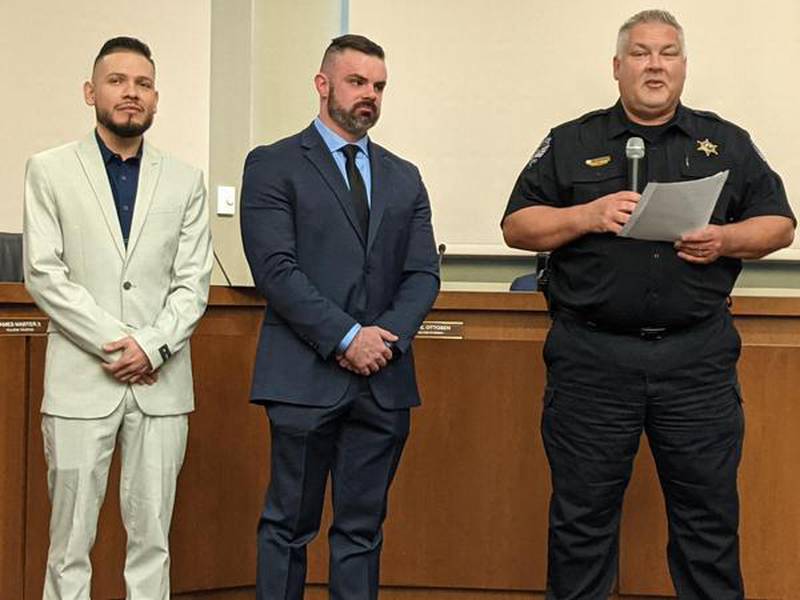 Oswego Police Chief Jeffrey Burgner, right, introduces new patrol officers Manuel Banuelos, lef,t and Cayman Cherry, middle, during the April 18 Oswego Village Board meeting.