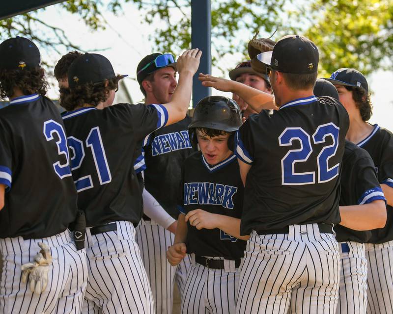 Newark's Weston Friestad, center, gets congratulated by teammates after scoring from a balk by Somonauk’s pitcher during the game on Tuesday May 13, 2025, held at Somonauk High School.