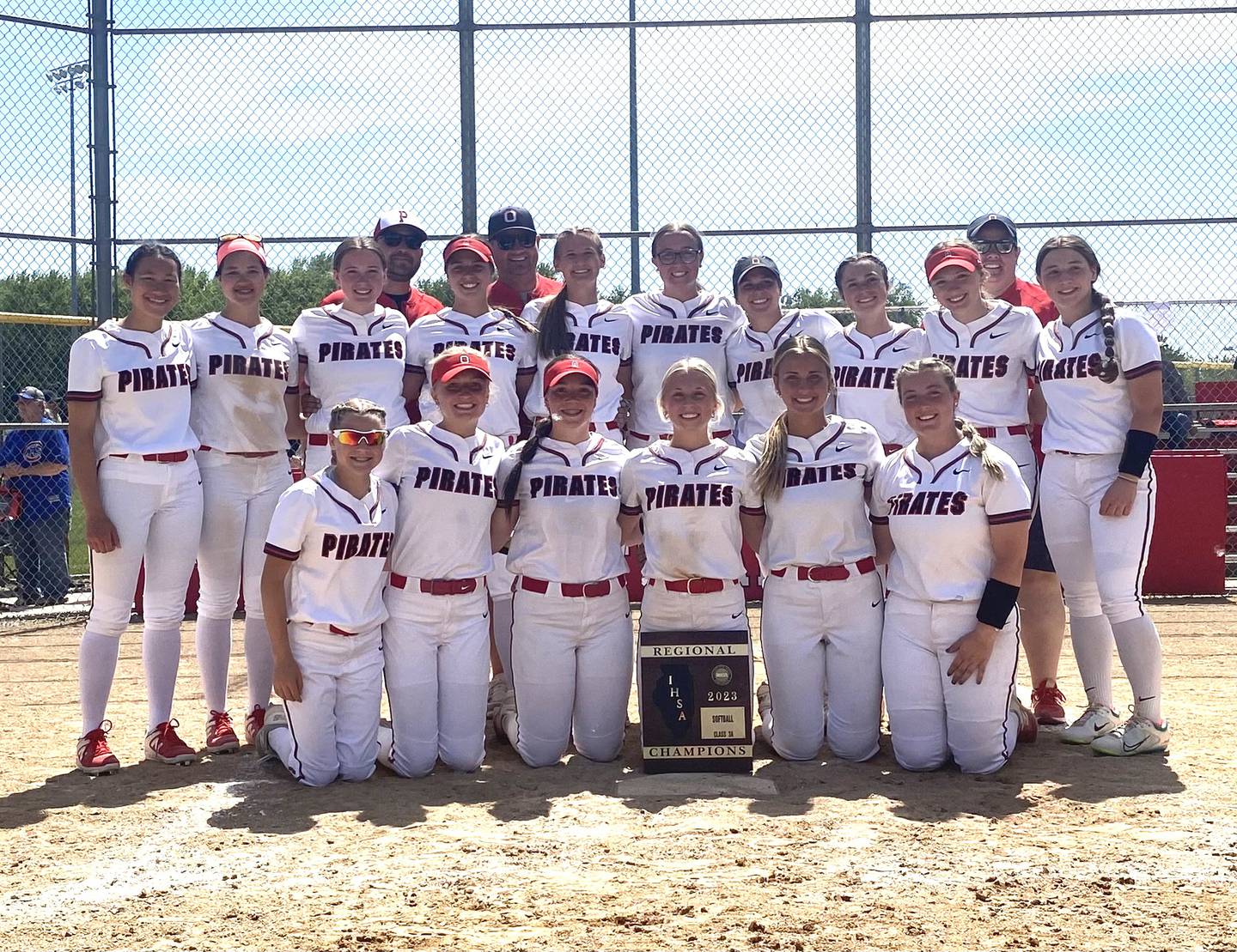 The Ottawa Pirates softball team assembles at home plate with its freshly won Class 3A Ottawa Regional championship plaque following a 5-1 win over Morris on Saturday, May 27, 2023.