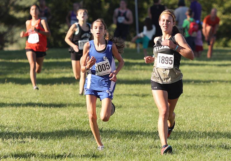 Sycamore's Hayley King (right) sprints for the finish line with Wheaton St. Francis' Margaret Andrzejewski Tuesday, Aug. 30, 2022, during the Sycamore Cross Country Invitational at Kishwaukee College in Malta.