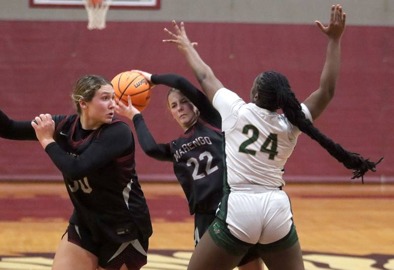 Marengo’s Sophie Hanson, center, looks for an option past St. Edwards’ Sanaii McPherson, right, in IHSA Regional Championship girls basketball on Thursday, Feb. 19, 2026, at Marengo High School in Marengo. Macy Noe of Marengo, left, follows the play.