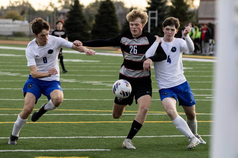 Lincoln-Way Central's Quinn Lauer fights to keep control of the ball as Lincoln-Way East's Sawyer Heersted and Cullen Johnson play defense during the 3A Joliet West Sectional boys varsity soccer match against at Joliet West on Oct. 29, 2025.