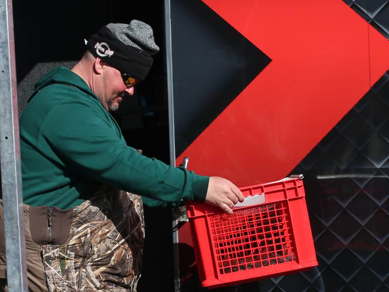 Jason Peach of Princeton, carries his fish basket across the stage after weighing his fish during the National Walleye Tour Masters Walley Circuit on Saturday, March 23, 2024 in Spring Valley.