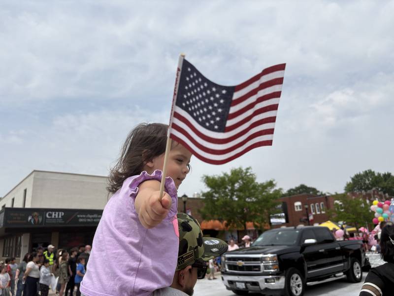 Nova Diaz, 2, of Naperville watches the Harvard Milk Days parade from her father's shoulders June 7, 2025.