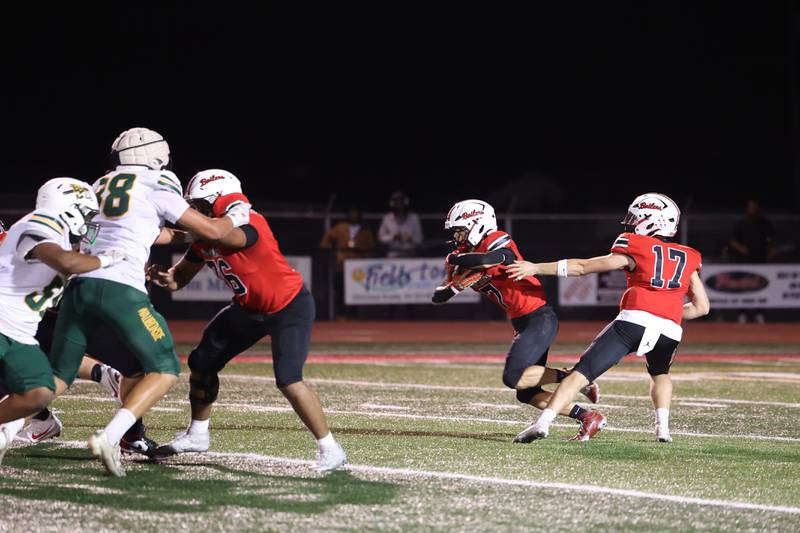 Bradley-Bourbonnais quarterback Ellis Johnson, right, hands the ball off to Isaac Allison during the Boilermakers' 35-6 victory over Waubonsie Valley Friday, Sept. 12, 2025.