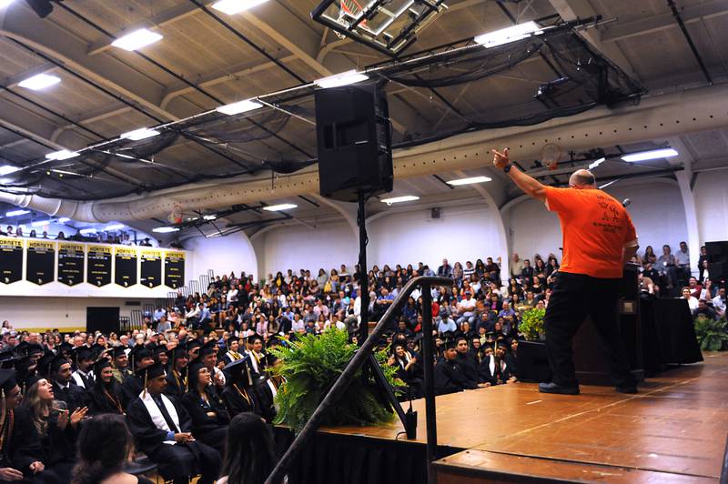 Commencement speaker John Hollingsworth shows off his dance moves Sunday, May 22, 2022, during the Harvard High School Commencement Ceremony in Harvard .