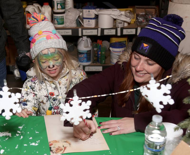 Brittany Sullivan (right) helps her daughter Isla Sullivan, 3, write a letter to Santa