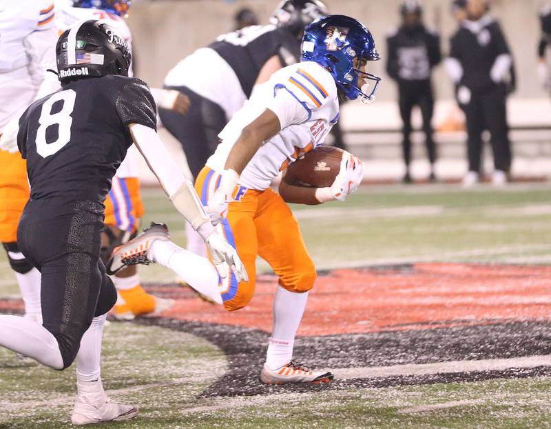 East St. Louis's Amir Tillman runs the ball past Fenwick's Jake Thies during the Class 6A State championship game on Tuesday, Dec. 2, 2025 in Hancock Stadium at Illinois State University in Normal.