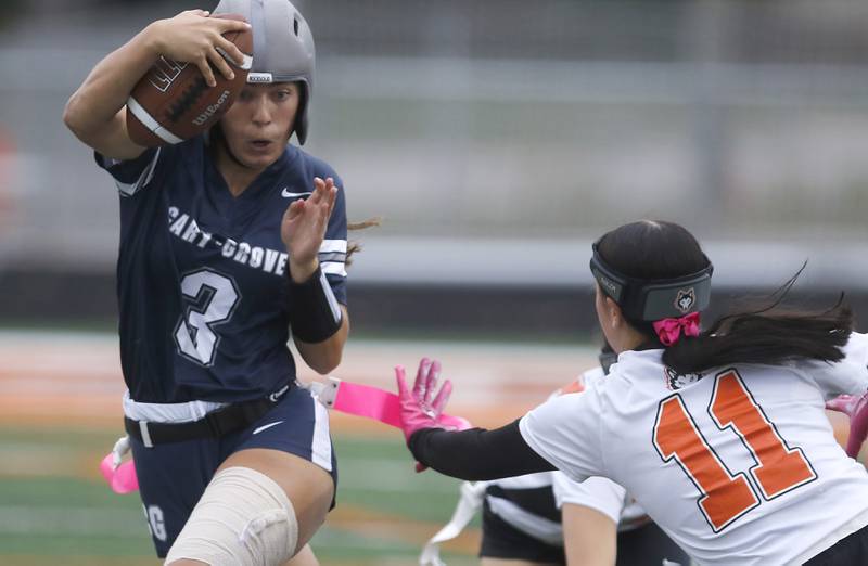 Cary-Grove's Kennedy Manning tries get away from Harlem’s Mel Ellis during an IHSA McHenry Sectional semifinal girls flag football game on Monday, Oct. 13, 2025, at McCracken Field in McHenry.