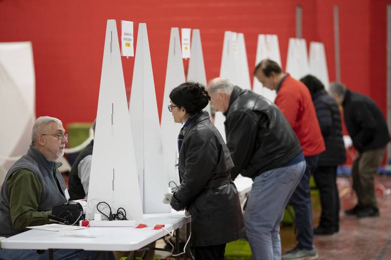 FILE - Voters check in to cast ballots in the New Hampshire presidential primary at a polling site in Derry, N.H., Jan. 23, 2024. (AP Photo/David Goldman, File)