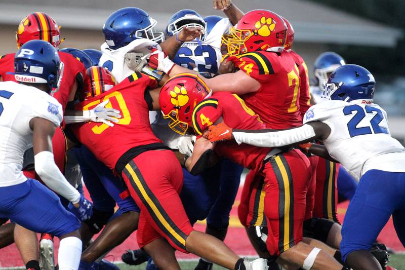 Batavia’s Charlie Whelpley (center) carries the ball into a mess of Phillips defense during the season-opener in Batavia on Friday, Aug. 25, 2023.