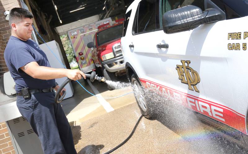 Juan Gaska, a firefighter paramedic with the DeKalb Fire Department, washes one of their vehicles Tuesday, May 16, 2023, at Fire Station 1 in DeKalb.