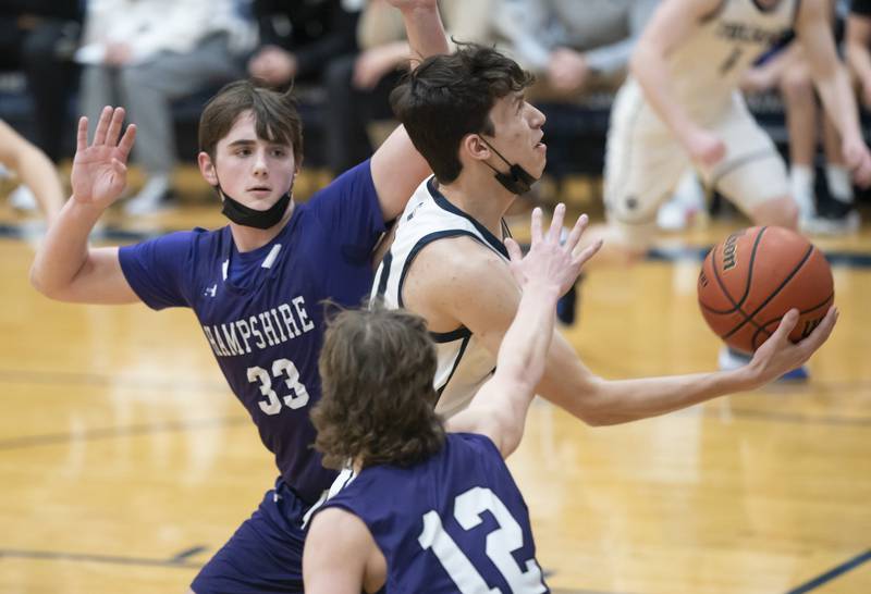 Cary-Grove's Zach Bauer eyes the basket past Hampshire defenders Sam Ptak, left, and Nicholas Louis during their game on Tuesday, January 25, 2022 at Cary-Grove High School in Cary.