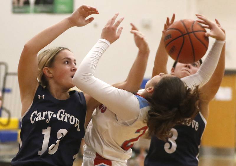 Cary-Grove's Malaina Kurth (left) and Kennedy Manning (right) battle with Marian Central's Kiara Kelly for a rebound on Thursday, Nov. 16, 2023, during Johnsburg Thanksgiving Tournament girls basketball game  at Johnsburg High School.