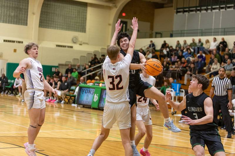 Glenbard West's Jacob Quintos goes in for the layup against Yorkville's Joey Jakstys on Friday Dec. 26,2025 at the 51st. Annual Jack Tosh Holiday Tournament in Elmhurst.