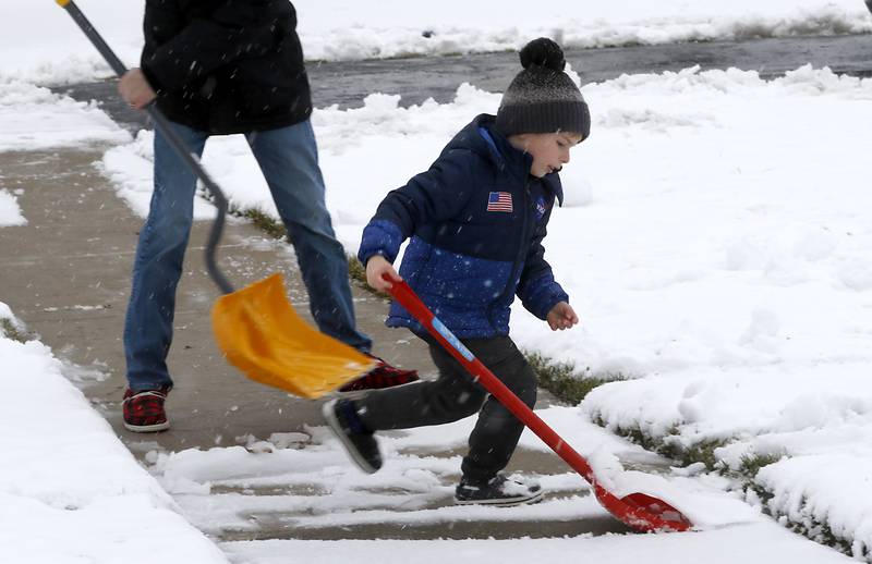 Liam Murray, 5, helps his dad, Cory, shovel the sidewalk in front of their home on Talisman Drive in Crystal Lake as a winter storm moves through McHenry County on Tuesday, Jan. 9, 2024, delivering snow to most of the county.