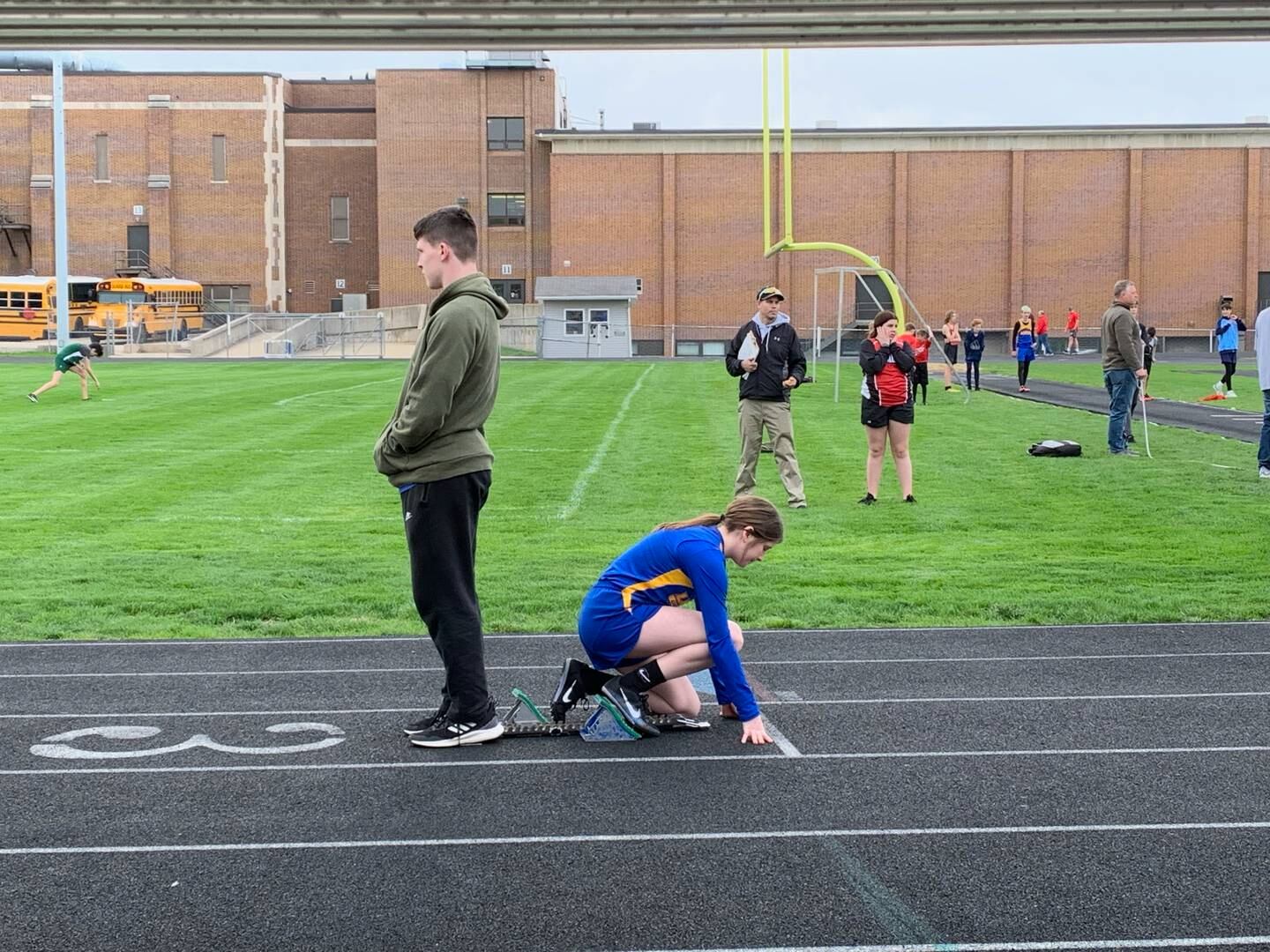 Princeton Logan 8th grader Camryn Driscoll gets a help from her brother, Evan, on the starting blocks in Monday's Bureau County meet. She won both the 100 and 400 meter dashes.