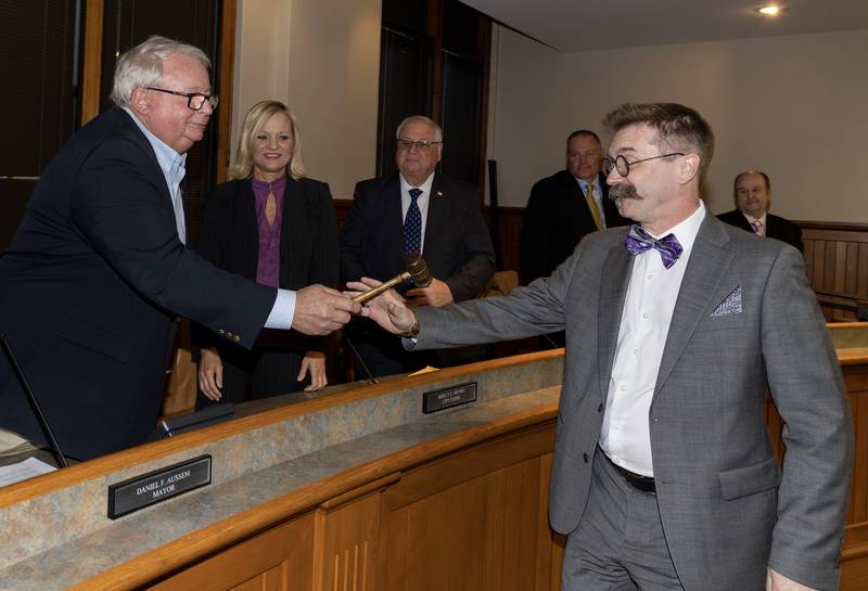 Dan Aussem hands over the gavel Tuesday, May 2, 2023, to Robert Hasty, who was elected mayor in the April 4 election.