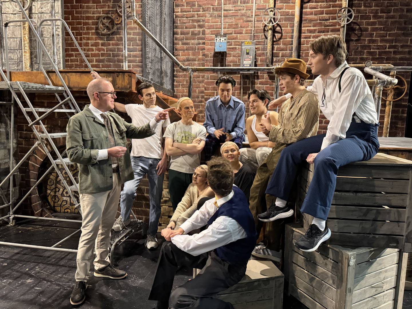 Cary-Grove High School Musical Director Rob Boncosky directs the cast of "Urinetown" before a show on March 8, 2026.