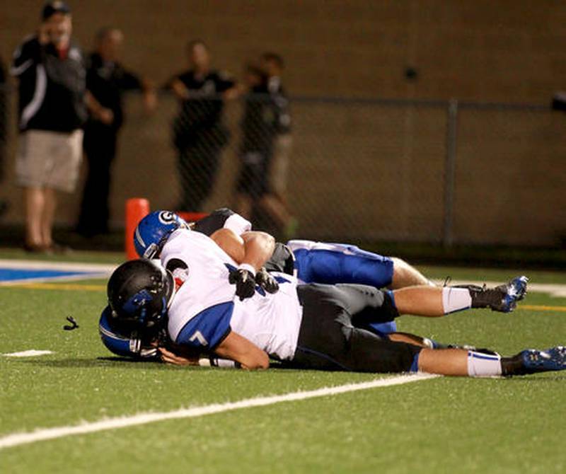 St. Charles North quarterback Erik Miller (7) is sacked by Geneva defender Billy Douds during their game Friday night at Geneva.