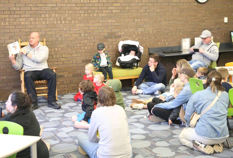 Captain Kevin Theis with the Ottawa FIre Department, reads to kids during story time on Thursday, April 10, 2025 at the Reddick Library in Ottawa.