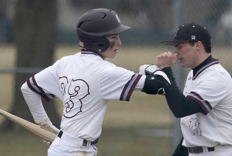 Marengo's Carter Heimsoth bumps his teammates Marengo's Ty Sierpien’s arm after scoring a run during a non-conference baseball game Wednesday, March 30, 2022, between Marengo and Hampshire at Marengo High School.