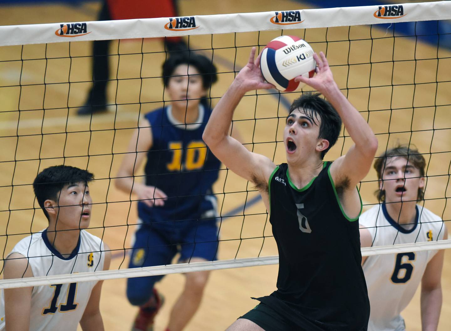 Glenbard West’s Jack Anderson sets the ball in front of Glenbrook South's Jaki Erdene during the state quarterfinal match at Hoffman Estates High School Friday.