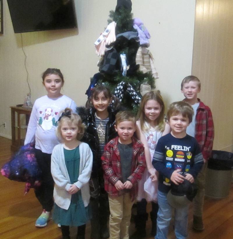 Pictured are many of the Plano Methodist Church's Sunday School Children with one of the hat and mitten trees displayed at the church. The church collected hats, mittens, gloves and scarves for the Kendall County Community Food Pantry.