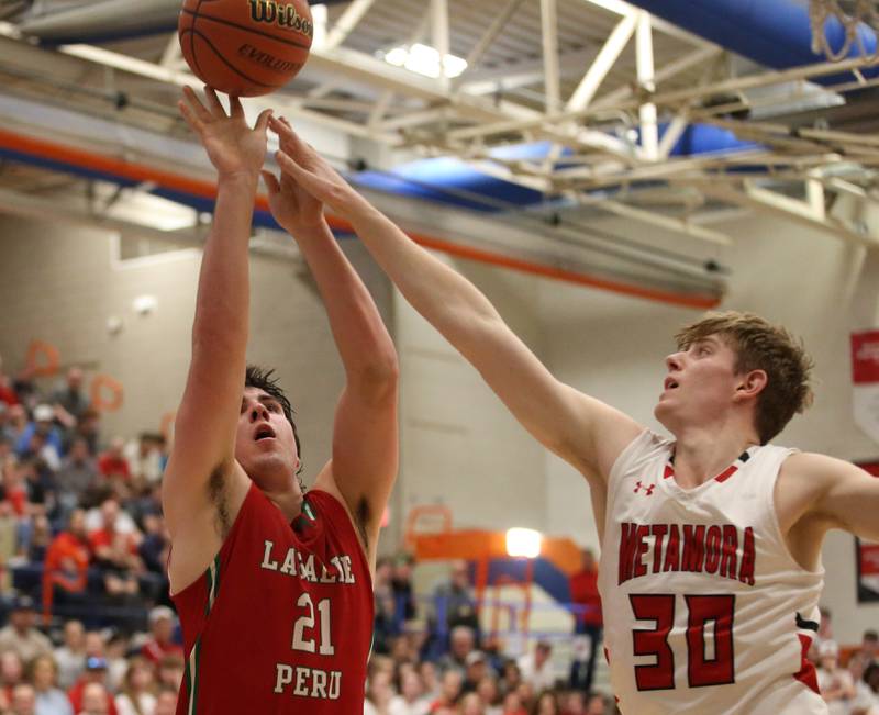 L-P's Josh Seneca lets go of a shot as Metamora's Cooper Koch defends during the Class 3A Sectional on Tuesday, Feb. 27, 2024 at Pontiac High School.