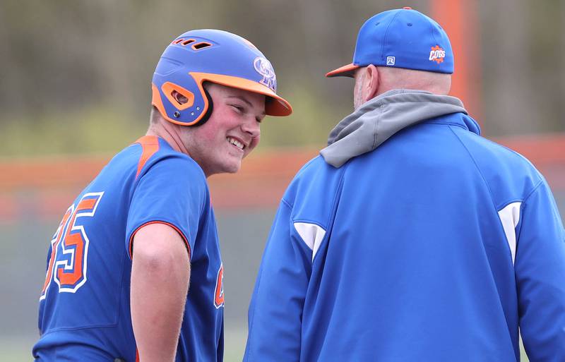 Genoa-Kingston's Evan Thompson has a laugh with head coach Roger Butler after taking third on a wild pitch during their game against Rockford Lutheran Tuesday, May 2, 2023, at Genoa-Kingston High School.