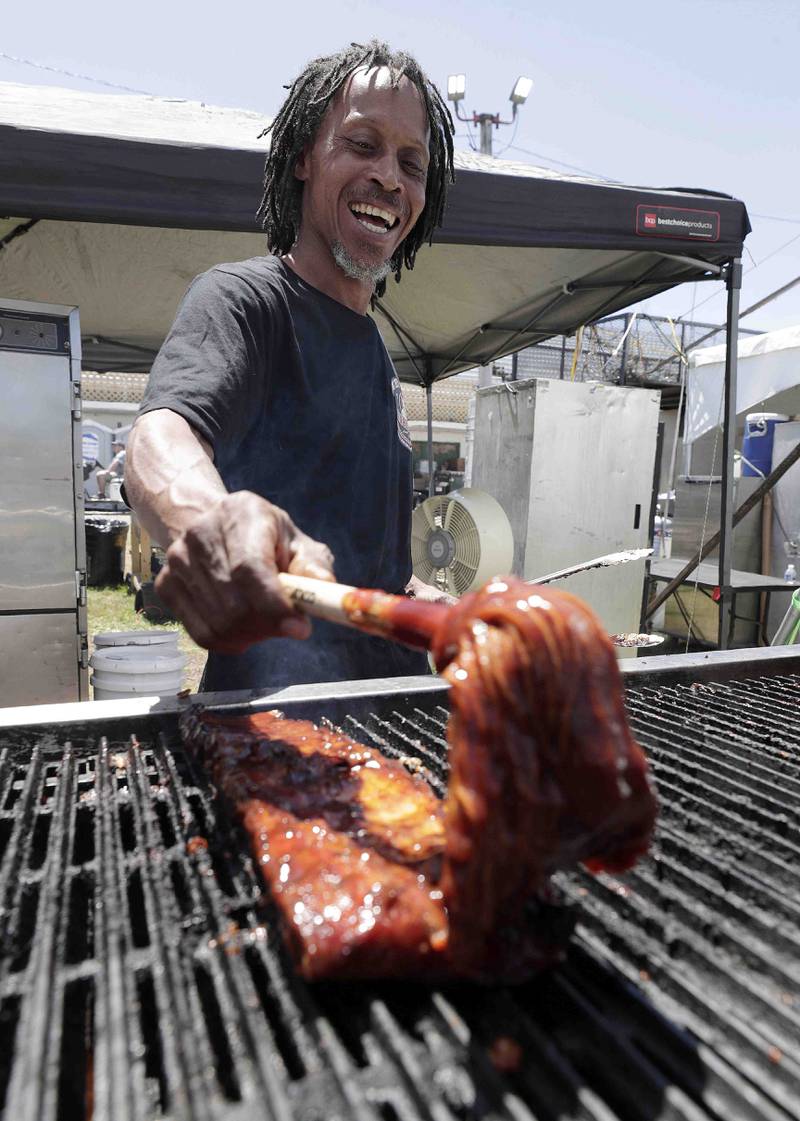 Levelle Perry sauces up some ribs for Uncle Bubs during opening day of Ribfest Friday June 17, 2022 at the DuPage County Fairgrounds in Wheaton. After 32 years in Naperville and then a pandemic pause, Ribfest has moved to the DuPage County Fairgrounds in Wheaton. The four-day event will be held over Father's Day weekend, just like the very first Ribfest in 1987.