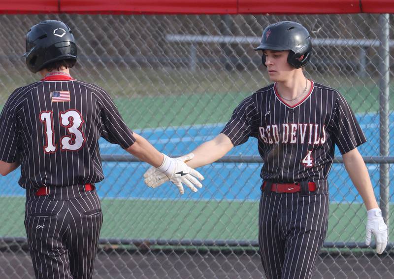 Hall's Luke Bryant hi-fives teammateNoah Plym after scoring a run against Streator on Thursday, March 19, 2026 at Streator High School.