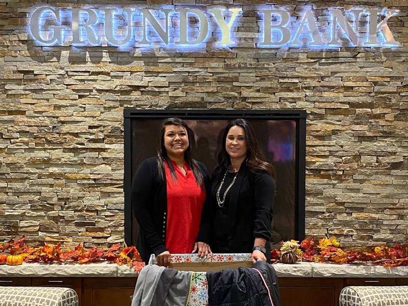 Christine Mendez (left) with the donation bin at Grundy Bank, 120 Liberty St. in Morris.