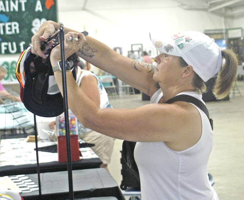 Jessica Kuebel of the Bougie Hat Bar adjusts a display at the Lee County Fair on Sunday, July 27, 2025.