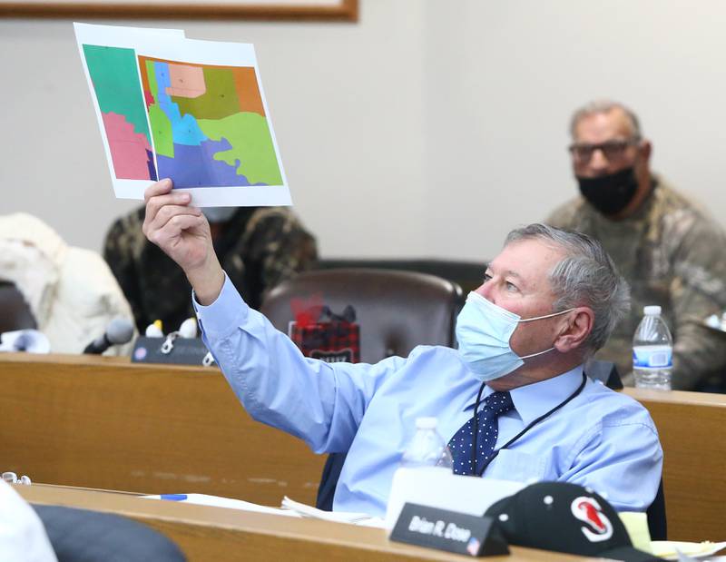 La Salle County Board member Doug Trager, holds up sections of maps that are not labeled on Monday Dec. 13, at the La Salle County Government Complex in Ottawa.