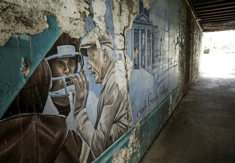 A dilapidated mural of coach Gordie Gillespie sits in a state of decay Tuesday in downtown Joliet.