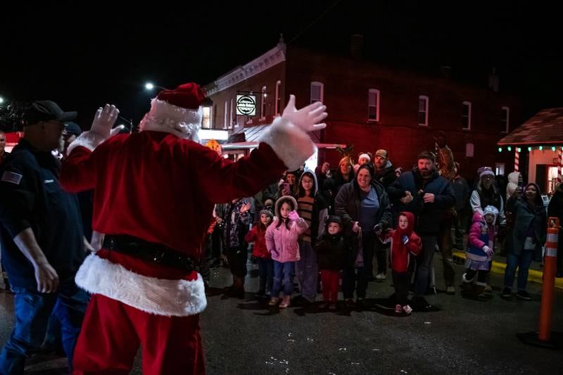 Santa Claus waves to the crowd huddled in downtown Genoa for the Genoa Area Chamber of Commerce’s annual Jingle Bell parade on Friday, Dec. 1, 2023.