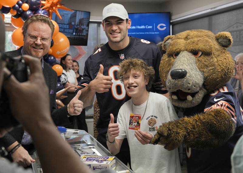 Jonah Davis, a 14-year-old heart patient from Downers Grove poses for pictures with Chicago Bears player Cole Kmet, Bears maskot Staley and Jonah’s doctor at a surprise party at Mark’s Card Shop in Downers Grove on Tuesday, Oct. 29, 2024.