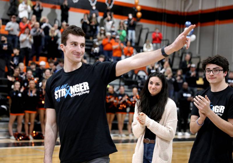 Justin Hardy, a former St. Charles East four-year varsity basketball player and current player for Washington University in St. Louis, waves to the crowd during a Hoops for Hope game in Hardy’s honor against Geneva in St. Charles Tuesday, Feb. 8, 2022. Hardy was diagnosed with Stage IV stomach cancer last April and continues to play basketball while undergoing treatment.