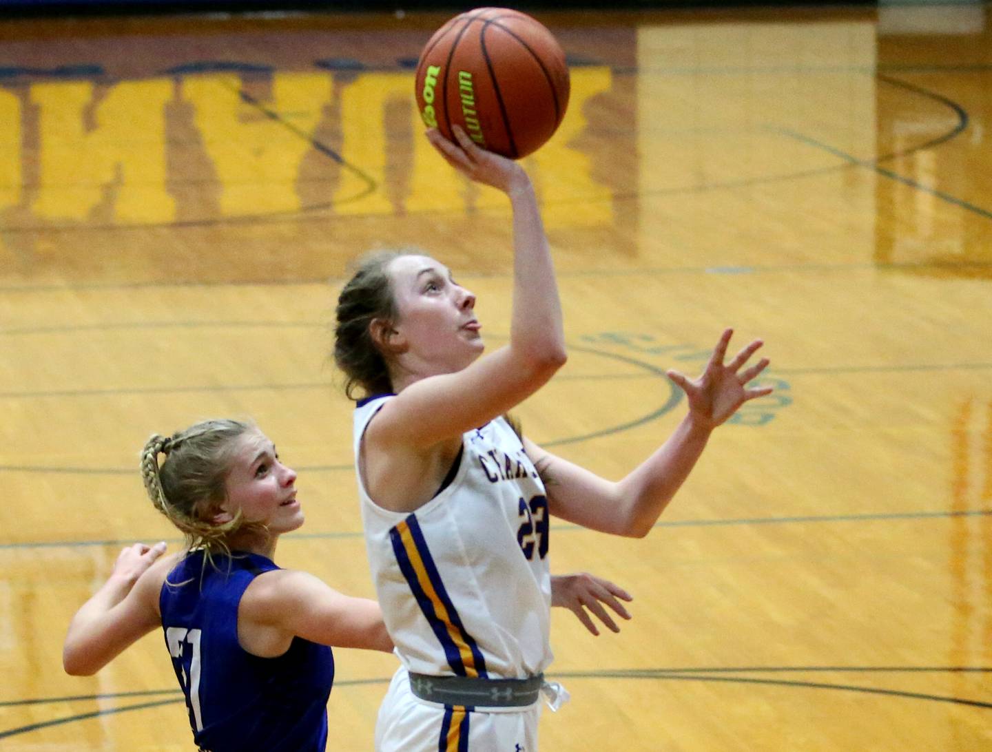 Aurora Central Catholic's Riley Cwinski (23) cuts in front of Newark's Addison Ness (21) to score a basket in the Tim Humes Breakout Tournament on Friday, Nov. 18, 2022 in Somonauk.