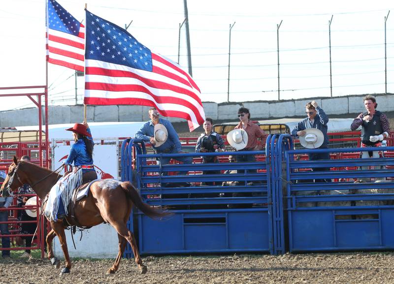 Cowboys watch the National Anthem being performed during the Starved Rock Rodeo on Saturday, June 21, 2025 at the La Salle Speedway.